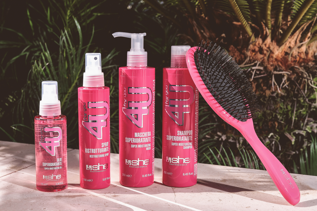 IN THIS PICTURE THEIR IS FOUR PINK HAIR PRODUCTS FROM SHE POFESSIONALS, ONE HAIR OIL, ONE RESTRUCTURING SPRAY, ONE SUPER MOISTURIZING MASK, ONE SUPER MOISTURIZING SHAMPOO AND A PINK BRUSH.