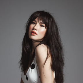 Model with long black/brown hair and tape in extensions. 